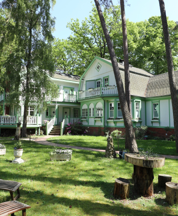 Eine histirusche Villa in einer Grünanlage.
