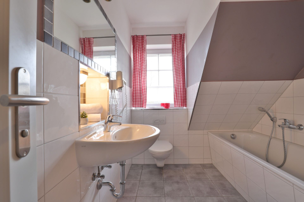 Badezimmer mit Waschbecken, Toilette und Badewanne