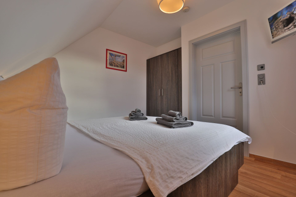 Schlafzimmer mit Doppelbett, TV, großer Kleiderschrank