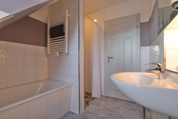 Badewanne, Waschbecken, Dusche und Zugangstür
