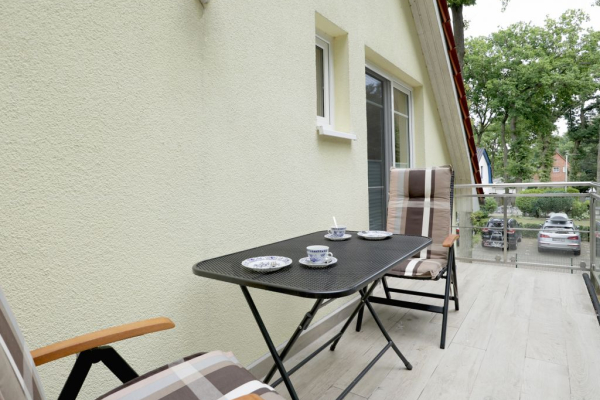 Blick auf einen Balkon mit einem Tisch und 2 Stühlen