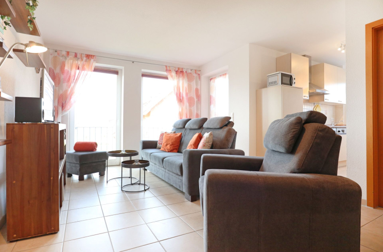 Blick auf das Sofa und den Hocker mit zwei kleinen Tischen