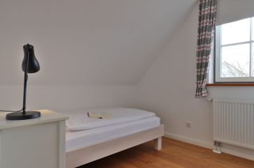 Ruhe-Insel Ferienhaus - Blick in das Schlafzimmer mit einem Einzelbett im OG