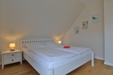Lillesand - Blick in ein Schlafzimmer mit einem Doppelbett im Obergeschoss