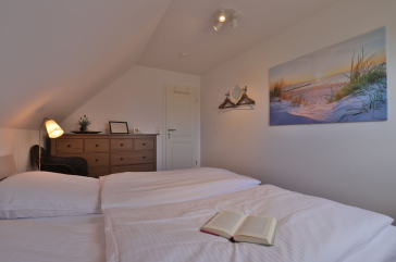 Ruhe-Insel Ferienhaus - Blick in das Schlafzimmer mit einem Doppelbett im OG
