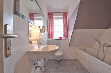 Badezimmer mit Waschbecken, Toilette und Badewanne
