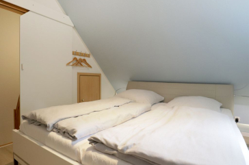 Blick in das Schlafzimmer im Spitzboden mit einem Doppelbett