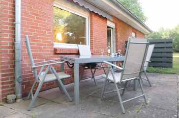Blick auf die Terrasse mit Tisch und 4 Stühlen.