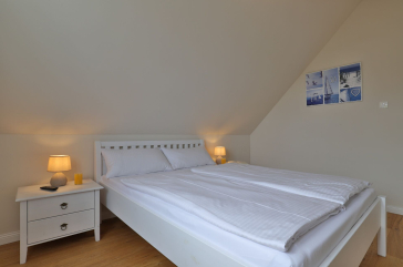 Lillesand - Blick in ein Schlafzimmer mit einem Doppelbett im Obergeschoss