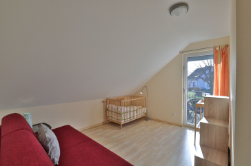 Strandgut Ferienhaus - Blick in das Gästezimmer mit Babybett und Wickeltisch