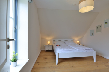 Lillesand - Blick in ein Schlafzimmer mit einem Doppelbett im Obergeschoss