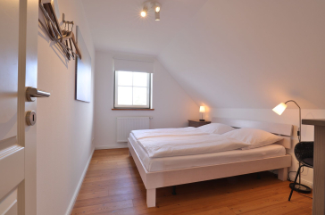 Ruhe-Insel Ferienhaus - Blick in das Schlafzimmer mit einem Doppelbett im OG