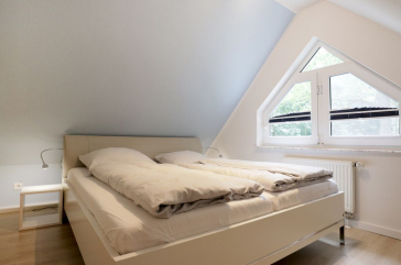 Blick in das Schlafzimmer im Spitzboden mit einem Doppelbett
