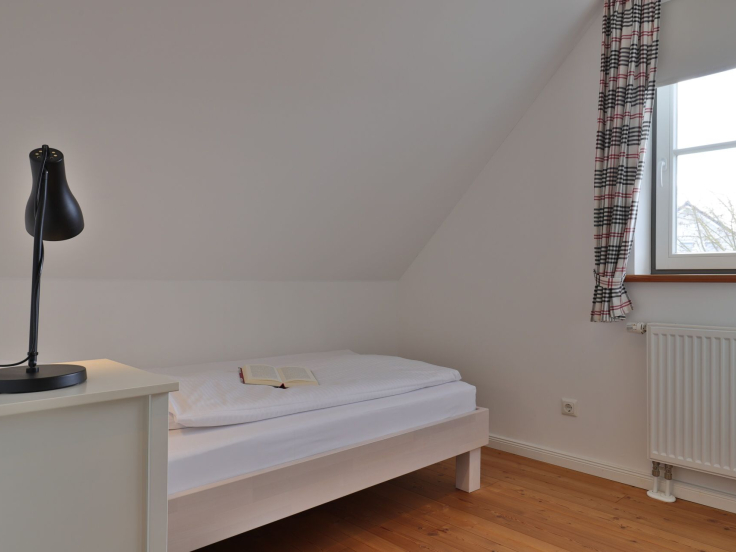 Ruhe-Insel Ferienhaus - Blick in das Schlafzimmer mit einem Einzelbett im OG