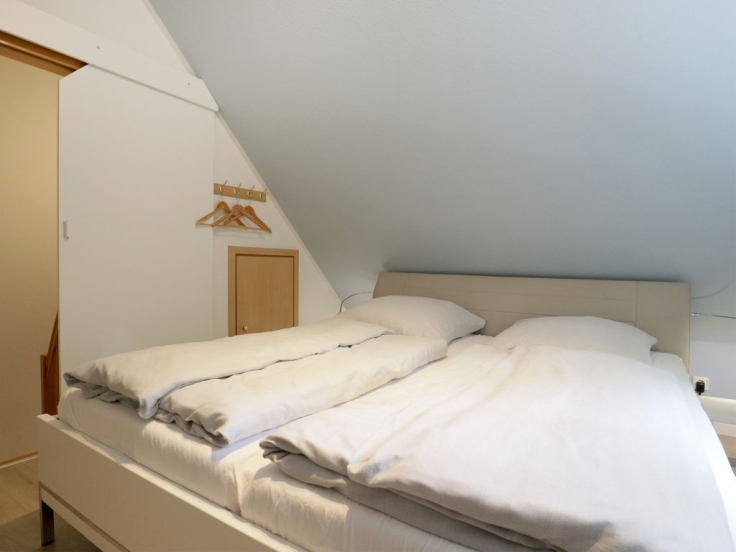Blick in das Schlafzimmer im Spitzboden mit einem Doppelbett