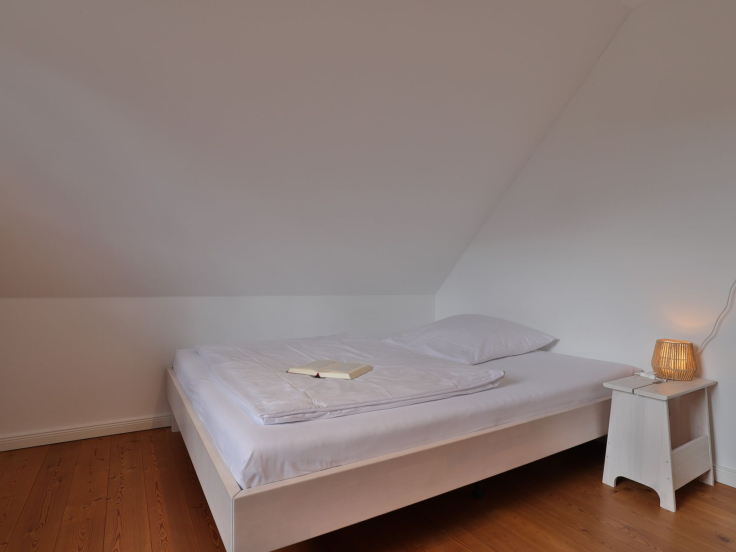 Ruhe-Insel Ferienhaus - Blick in das Schlafzimmer mit einem Einzelbett 1,40 m