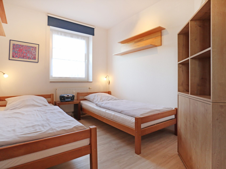 Blick in das Kinder-/ Gästezimmer mit 2 Einzelbetten und einem Regal