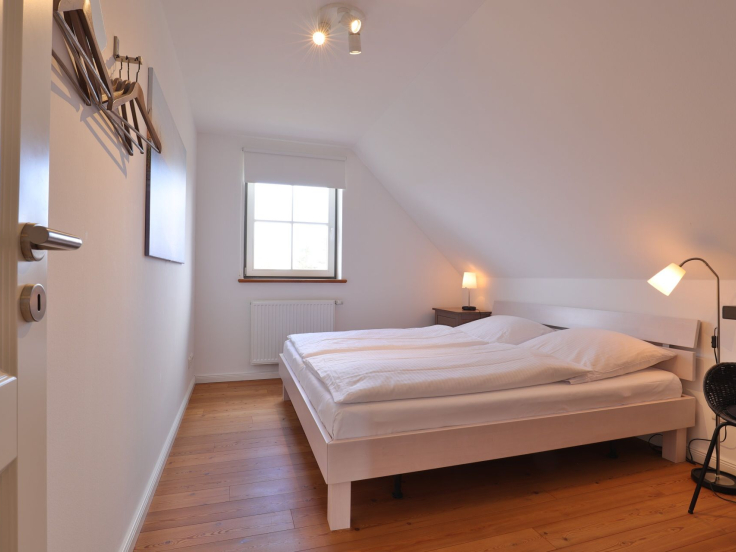 Ruhe-Insel Ferienhaus - Blick in das Schlafzimmer mit einem Doppelbett im OG