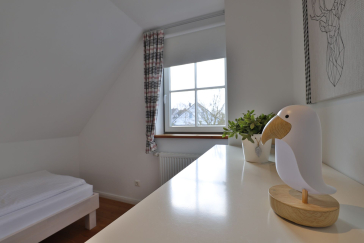 Ruhe-Insel Ferienhaus - Blick in das Schlafzimmer mit einem Einzelbett im OG