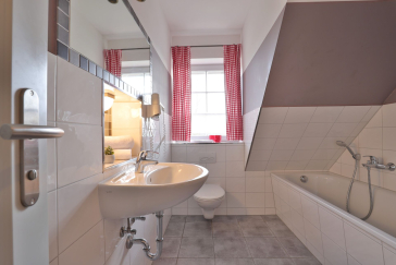 Badezimmer mit Waschbecken, Toilette und Badewanne