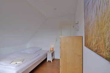 Ruhe-Insel Ferienhaus - Blick in das Schlafzimmer mit einem 1,40m Bett im OG