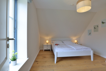 Lillesand - Blick in ein Schlafzimmer mit einem Doppelbett im Obergeschoss