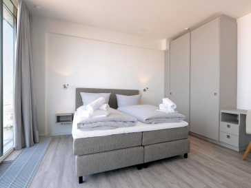 Schlafbereich mit Doppelbett und großem Kleiderschrank