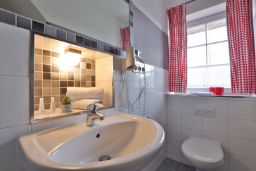 Waschbecken mit Toilette, Fenster darüber