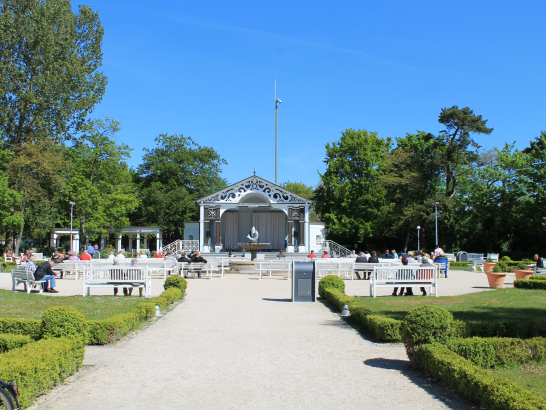 Ein Park. Weiße Kieswege führen durch eine Grünanlage. 