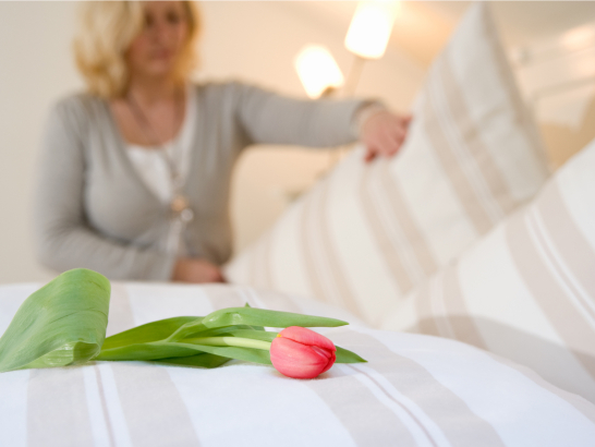 frisch gemachtes Bett in gepflegter Unterkunft