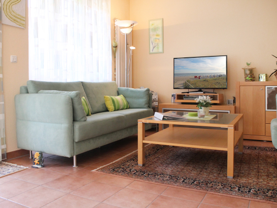 Sitzbereich im Wohnzimmer mit Sofa, Couchtisch und Fernseher