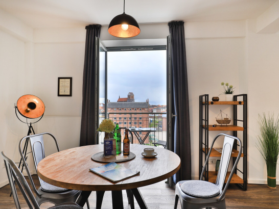 Esstisch mit Stühlen im Industriedesign und Blick auf den Balkon