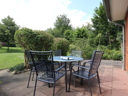 Sitzgarnitur auf Terrasse mit Blick auf den umliegenden Garten